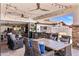An outdoor kitchen featuring a built-in grill, stone countertops, and comfortable wicker seating under string lights at 7510 E Larkspur Dr, Scottsdale, AZ 85260