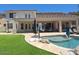 Gorgeous backyard featuring a covered patio, pool with stone accents, and artificial turf at 7527 E Nestling Way, Scottsdale, AZ 85255