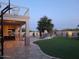 Expansive backyard featuring a covered patio, basketball court, lush lawn, and a rock waterfall cascading into a pool at 7527 E Nestling Way, Scottsdale, AZ 85255