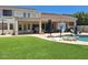 Expansive backyard with lush artificial turf, covered patio, and refreshing pool at 7527 E Nestling Way, Scottsdale, AZ 85255