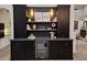 Custom wet bar with a wine refrigerator, stylish backsplash, and open shelving at 7527 E Nestling Way, Scottsdale, AZ 85255