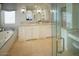 Bright bathroom featuring a jacuzzi tub, dual sinks, walk-in shower, vanity area, and neutral colors at 7527 E Nestling Way, Scottsdale, AZ 85255