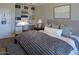 Bright bedroom featuring a large bed with shelving, a workstation, and neutral colors at 7527 E Nestling Way, Scottsdale, AZ 85255