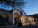 Beautiful stucco home with a three-car garage, arched entry, and desert landscaping at 7527 E Nestling Way, Scottsdale, AZ 85255