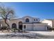 Elegant home featuring an arched entryway, desert landscaping, and a spacious three-car garage at 7527 E Nestling Way, Scottsdale, AZ 85255