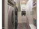 Neat laundry room featuring a washer, dryer, shelving, storage, and attractive tile flooring at 7527 E Nestling Way, Scottsdale, AZ 85255