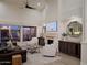Spacious living room featuring tall ceilings, fireplace, lots of natural light, and hardwood floors at 7527 E Nestling Way, Scottsdale, AZ 85255