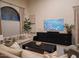 Comfortable living room featuring neutral tones, large arched window, and a stylish entertainment center at 7527 E Nestling Way, Scottsdale, AZ 85255