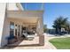 Covered patio overlooking a pool, lush greenery and an outdoor kitchen at 7527 E Nestling Way, Scottsdale, AZ 85255