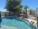 Amazing pool with rock waterfall feature and lush landscaping for a serene backyard retreat at 7527 E Nestling Way, Scottsdale, AZ 85255