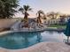 Stunning custom pool with waterfall, slide, and mature palm trees at 7527 E Nestling Way, Scottsdale, AZ 85255