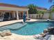 Inviting pool featuring an umbrella, chaise lounges, and beautiful backyard landscaping at 7527 E Nestling Way, Scottsdale, AZ 85255