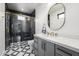 Bathroom with black accent tiles, round mirror and gray vanity at 7851 N Central Ave, Phoenix, AZ 85020