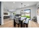 A modern dining room with stylish table and seating next to the kitchen island and with backyard views at 7851 N Central Ave, Phoenix, AZ 85020