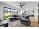 Inviting living room with a large sectional couch and expansive windows showcasing the lush backyard and natural light at 7851 N Central Ave, Phoenix, AZ 85020
