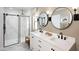Bright bathroom featuring double sinks, modern fixtures, and a spacious glass-enclosed shower at 8000 W Griswold Rd, Peoria, AZ 85345