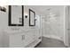 Modern bathroom with a double vanity, a glass shower with marble, black framed mirrors, and recessed lighting at 8000 W Griswold Rd, Peoria, AZ 85345