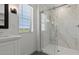 This bathroom features a glass shower with marble and a modern vanity with bright natural light from a nearby window at 8000 W Griswold Rd, Peoria, AZ 85345