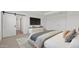 Bright main bedroom featuring large TV, with a sliding barn door to the Primary bathroom, and a designer bed at 8000 W Griswold Rd, Peoria, AZ 85345