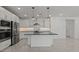 Bright kitchen featuring stainless steel appliances, gray countertops, and a large center island with modern lighting at 8000 W Griswold Rd, Peoria, AZ 85345