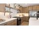 Contemporary kitchen with white countertops, wooden cabinetry, stainless steel appliances and tile backsplash at 8000 W Griswold Rd, Peoria, AZ 85345