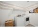 Functional laundry area with modern side-by-side washer and dryer, plus a basket at 8000 W Griswold Rd, Peoria, AZ 85345