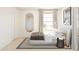 Bright bedroom featuring a modern bed, oval mirror, neutral colors and a minimalist design at 8024 W Griswold Rd, Peoria, AZ 85345