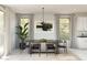 Elegant dining area with a sleek table, stylish chairs, and abundant natural light from large windows at 8024 W Griswold Rd, Peoria, AZ 85345