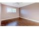 Bedroom featuring hardwood floors, window with blinds, and neutral colored walls at 8713 E Sage Dr, Scottsdale, AZ 85250
