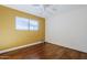 Bedroom featuring wood floors, yellow accent wall, and ceiling fan at 8713 E Sage Dr, Scottsdale, AZ 85250