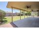 Covered patio with ceiling fans, tiled flooring, and views of the expansive, well-maintained backyard at 8713 E Sage Dr, Scottsdale, AZ 85250