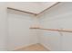 Walk-in closet features wood rods for hanging clothes and tile floors at 9243 W Brown St, Peoria, AZ 85345