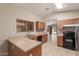 Open kitchen with wood cabinets, tile floor, and black appliances at 9243 W Brown St, Peoria, AZ 85345