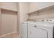Functional laundry room equipped with a modern washer and dryer set and overhead storage at 9243 W Brown St, Peoria, AZ 85345