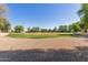 Gravel pathway leading to a park with lush green trees and open lawn at 9243 W Brown St, Peoria, AZ 85345