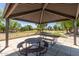 Park picnic area under a metal shade structure with views of playground at 9243 W Brown St, Peoria, AZ 85345