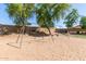 Playground swingset with sand ground cover next to lush green trees at 9243 W Brown St, Peoria, AZ 85345