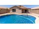 Backyard pool with a rock border and tan-colored stucco home in a sunny setting at 9243 W Brown St, Peoria, AZ 85345