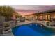 Beautiful backyard at dusk showcasing a sparkling pool, outdoor grill, and inviting patio area at 9432 E Quail Trl, Carefree, AZ 85377