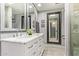 Bathroom with double sinks, marble counters, decorative mirrors, and wood-style floors at 9432 E Quail Trl, Carefree, AZ 85377