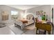 Sunlit bedroom featuring a patterned bedspread, desk, and decorative wall art at 9432 E Quail Trl, Carefree, AZ 85377