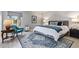 Cozy bedroom featuring a plush bed, stylish rug, blue accent chair, and natural light at 9432 E Quail Trl, Carefree, AZ 85377