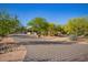 Desert home with a long driveway surrounded by lush greenery, and xeriscaping at 9432 E Quail Trl, Carefree, AZ 85377