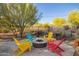 Cozy fire pit surrounded by colorful Adirondack chairs, perfect for evening relaxation and entertaining at 9432 E Quail Trl, Carefree, AZ 85377