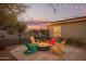 Backyard firepit area with Adirondack chairs and bistro lights creating a cozy desert retreat at 9432 E Quail Trl, Carefree, AZ 85377
