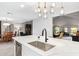 Spacious kitchen island with stone countertop, stainless sink, modern faucet, and pendant lighting at 9432 E Quail Trl, Carefree, AZ 85377