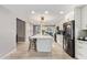 Open kitchen with island, bar seating, white cabinets, stainless appliances, and wood-look flooring at 9432 E Quail Trl, Carefree, AZ 85377