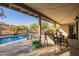 Inviting covered patio with dining area overlooking the sparkling pool and serene desert landscape at 9432 E Quail Trl, Carefree, AZ 85377