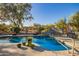 Stunning pool area with lush desert landscaping, waterfall feature, and relaxing lounge chairs at 9432 E Quail Trl, Carefree, AZ 85377