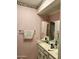 Cozy bathroom featuring pink wallpaper, classic fixtures, and a double vanity at 10102 E Michigan Ave, Sun Lakes, AZ 85248